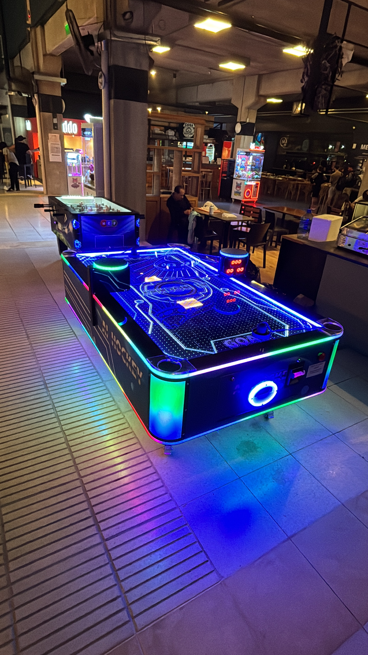 Máquina de air hockey funcionando en el patio de comidas de un local comercial